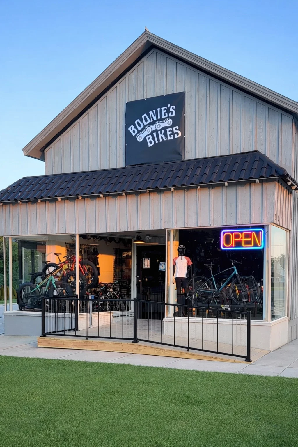 Person behind a counter in a store with wooden floors and ceiling fans.