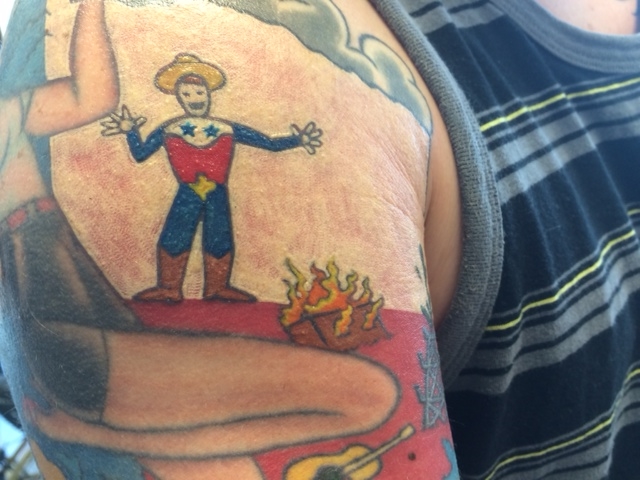 A customer's Texas-themed tattoo. Yup, that's Waco on fire.